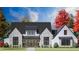 Beautiful two-story home featuring a brick and white-wood exterior, black-trimmed windows, and manicured landscaping at 1276 B Rutledge Rd, Acworth, GA 30101