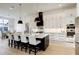 Modern kitchen with white cabinets, black accents, a large island with seating, and stainless steel appliances at 1276 B Rutledge Rd, Acworth, GA 30101