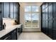 Extra-large walk-in pantry with black cabinets, white countertops, and a view to the exterior at 1276 B Rutledge Rd, Acworth, GA 30101