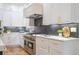 Kitchen with a professional range, modern backsplash, and custom cabinets with gold hardware at 1653 Pamela Ne Dr, Brookhaven, GA 30319