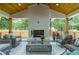 Outdoor living space featuring a stone fireplace, ample seating, and views of the backyard at 1653 Pamela Ne Dr, Brookhaven, GA 30319