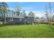 Exterior view of backyard with brick facade, manicured lawn and mature trees at 3048 San Jose Dr, Decatur, GA 30032