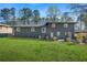 Exterior view of the backyard with brick facade, manicured lawn and mature trees at 3048 San Jose Dr, Decatur, GA 30032