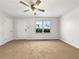 Inviting living room featuring neutral carpet, a bright window, and a door to additional spaces at 3686 Sweetbriar Cir, Lithia Springs, GA 30122