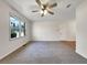 Spacious living room with neutral carpet, a ceiling fan, and a large window overlooking the outdoor landscape at 3686 Sweetbriar Cir, Lithia Springs, GA 30122