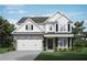 Charming two-story home featuring a stone facade, white siding, black shutters, and a manicured lawn at 3856 Lockaby Way, Lawrenceville, GA 30044