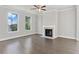 Spacious living room with hardwood floors, fireplace, ceiling fan, and abundant natural light at 3856 Lockaby Way, Lawrenceville, GA 30044