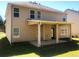 View of the rear exterior showing a covered patio and a large, grassy backyard at 6645 Oak Hill Pass, Fairburn, GA 30213