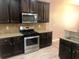 Kitchen with stainless steel appliances, granite countertops, and dark wood cabinetry at 6645 Oak Hill Pass, Fairburn, GA 30213