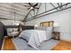 Bright bedroom with hardwood floors, decorative metal beams, comfortable chair, and a queen bed at 1661 La France Ne St # 314, Atlanta, GA 30307