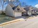 Street view of townhome featuring attached garage, dark roof, and manicured lawn at 218 Hickory Commons Way, Canton, GA 30115