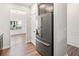 Stainless steel refrigerator with dining room on one side and kitchen on the other at 218 Hickory Commons Way, Canton, GA 30115
