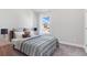 Cozy bedroom with natural light from the window, complemented by carpet flooring and neutral tones at 3786 Lockaby Way, Lawrenceville, GA 30044