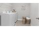 Cozy laundry room with tile flooring, modern washer and dryer, and woven basket decor at 3786 Lockaby Way, Lawrenceville, GA 30044