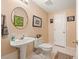 Cozy powder room features a pedestal sink, white tile floors, and charming decor at 3847 Sweet Bottom Dr, Duluth, GA 30096