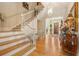 Welcoming foyer with hardwood staircase, decorative chest, and beautiful lighting fixture at 3847 Sweet Bottom Dr, Duluth, GA 30096