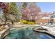 Stunning pool with a waterfall feature, spa, and mature landscaping in a private backyard oasis at 3847 Sweet Bottom Dr, Duluth, GA 30096