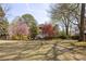 Spacious backyard with mature trees, wrought iron fencing, and a view of the house at 3847 Sweet Bottom Dr, Duluth, GA 30096