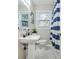 Cozy bathroom features a pedestal sink, toilet, and shower with a blue and white striped curtain at 1013 Columbia Dr, Decatur, GA 30030