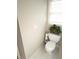 Compact bathroom featuring a toilet, window, and a decorative touch with a small potted plant at 3655 Brisbane Dr, Marietta, GA 30062