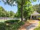 A tennis court view with beautiful trees and a covered patio overlooking a paved path at 3655 Brisbane Dr, Marietta, GA 30062