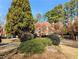 Charming home exterior featuring mature trees, lush landscaping, and a well-maintained lawn at 3655 Brisbane Dr, Marietta, GA 30062