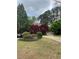 Landscaped front yard with green grass, driveway, shrubs, trees, and a glimpse of the home at 3655 Brisbane Dr, Marietta, GA 30062