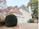 Two-car garage of a two-story home with white trim, a chimney, and surrounding greenery at 3655 Brisbane Dr, Marietta, GA 30062