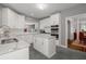 Modern kitchen with white cabinets, island, stainless steel appliances, and grey backsplash and floor tiles at 3655 Brisbane Dr, Marietta, GA 30062