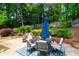 Outdoor patio area with a dining table set surrounded by a landscaped backyard at 3655 Brisbane Dr, Marietta, GA 30062