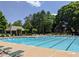 Large community pool surrounded by trees and greenery, featuring a covered gazebo at 3655 Brisbane Dr, Marietta, GA 30062