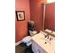 An updated half bathroom offers a decorative mirror, wooden floors, and earth-tone paint at 3655 Brisbane Dr, Marietta, GA 30062