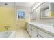 Bathroom with dual sinks, neutral countertops, and tub with tile surround at 4433 Canary Ct, Lithia Springs, GA 30122