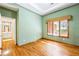Bedroom with hardwood floors features large window and a private bath at 5595 Rolling Acres Ln, Cumming, GA 30028