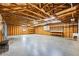 Spacious garage interior features wooden beams, high ceilings, and concrete floors at 5595 Rolling Acres Ln, Cumming, GA 30028
