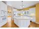 Bright kitchen features white cabinets, central island cooktop, and stainless-steel appliances at 5595 Rolling Acres Ln, Cumming, GA 30028