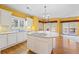 Kitchen features an island with cooktop and white cabinets at 5595 Rolling Acres Ln, Cumming, GA 30028