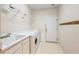 Well-lit laundry room featuring a utility sink, washer, dryer, and overhead shelving at 5595 Rolling Acres Ln, Cumming, GA 30028