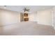 Open living room with a ceiling fan, neutral walls, and a wet bar with granite countertops at 5595 Rolling Acres Ln, Cumming, GA 30028