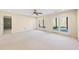 Spacious living room with plush carpeting, ceiling fan, and access to outdoor patio through double doors at 5595 Rolling Acres Ln, Cumming, GA 30028