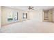 Open living room with plush carpeting, ceiling fan, and access to outdoor patio through double doors at 5595 Rolling Acres Ln, Cumming, GA 30028
