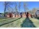 Backyard view of a brick home with a large grassy area, mature trees, and a chain link fence at 642 Dogwood Dr, Lawrenceville, GA 30046