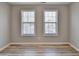 An empty bedroom with two large windows, blinds, and new vinyl flooring at 642 Dogwood Dr, Lawrenceville, GA 30046