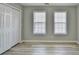 A bedroom featuring a closet and two large windows with blinds and new vinyl flooring at 642 Dogwood Dr, Lawrenceville, GA 30046
