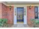 Close-up of the home's front door with sidelights and decorative exterior lighting at 642 Dogwood Dr, Lawrenceville, GA 30046