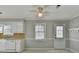 Cozy kitchen with white cabinets, a window, and access to an outside door at 642 Dogwood Dr, Lawrenceville, GA 30046