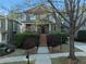 Charming two-story brick home featuring a covered front porch and meticulously landscaped front yard with mature trees at 2019 Mason Mill Rd, Decatur, GA 30033