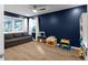 Bright living room with hardwood floors, gray sofa, multiple windows, and a blue accent wall at 2019 Mason Mill Rd, Decatur, GA 30033