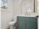 Powder room with marble countertop, gold accents, and green vanity at 2848 Tanner Lake Nw Trl, Marietta, GA 30064