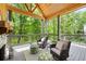 Charming screened porch with stone fireplace, outdoor seating, and forest view at 2848 Tanner Lake Nw Trl, Marietta, GA 30064